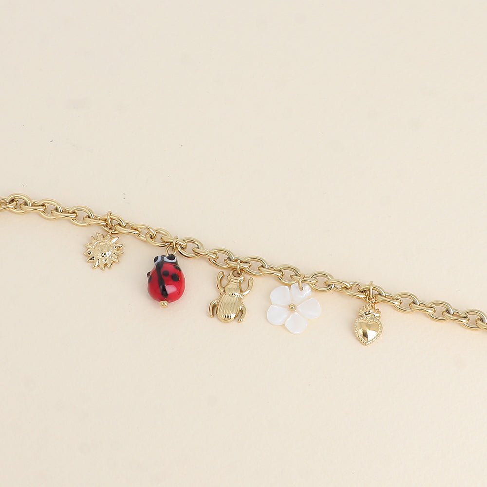 Bracelet - pendentifs (soleil, coccinelle en céramique émaillée, scarabée, fleur nacrée, cœur)
